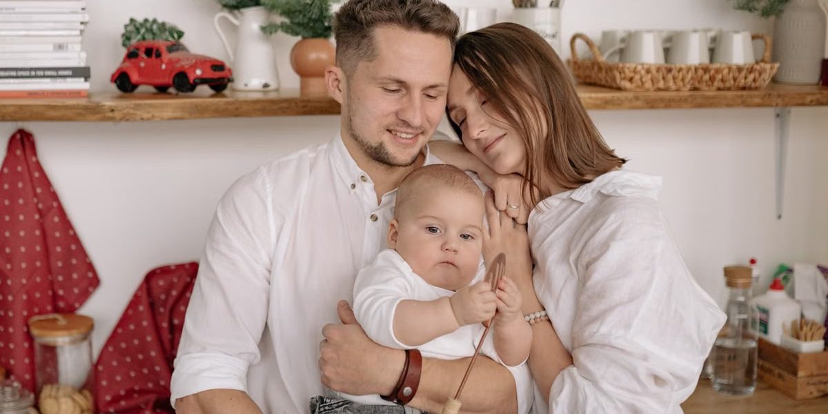 A joyful family of three embracing in a cozy kitchen. Warm and loving atmosphere.