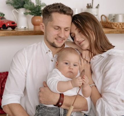A joyful family of three embracing in a cozy kitchen. Warm and loving atmosphere.